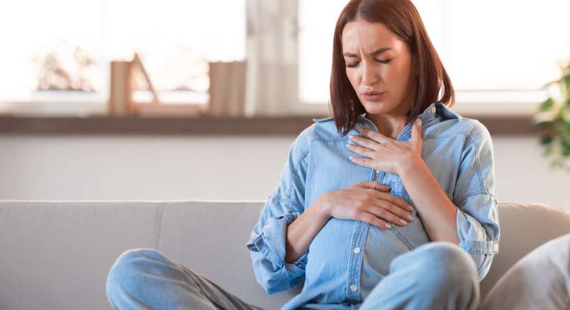 امرأة حامل تبدو منزعجة من الارتجاع المريئي