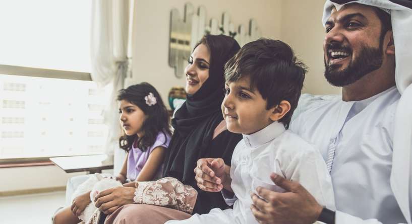أفراد العائلة يشاهدون التلفاز بسعادة
