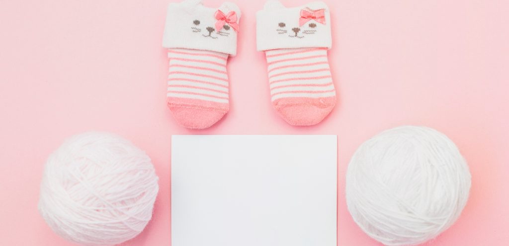 جراب طفلة باللون الزهري مع طابتين من الصوف