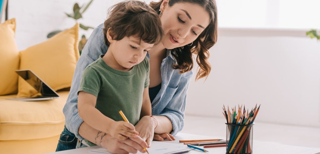 أمّ تمسك مع طفلها القلم