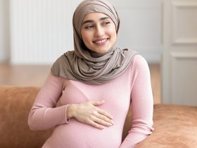امرأة حامل تجلس على الأريكة