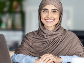 شابة تجلس أمام الحاسوب