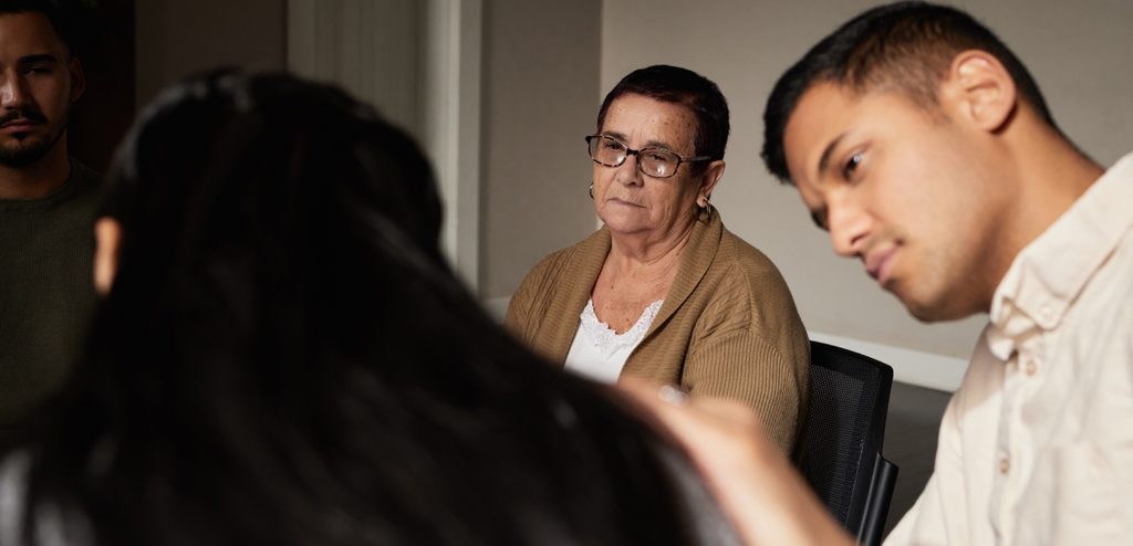 رجل ينظر إلى امرأة وأمامهما امرأة كبيرة في السن