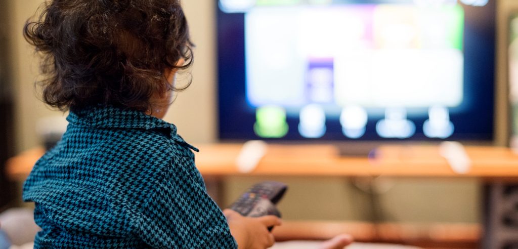 طفل يجلس أمام التلفاز