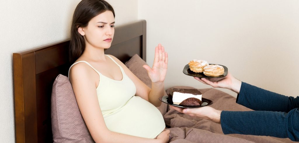 امرأة حامل مستلقية في السرير ترفض الطعام