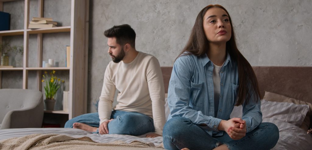 زوجان حزينان يجلسان على السرير