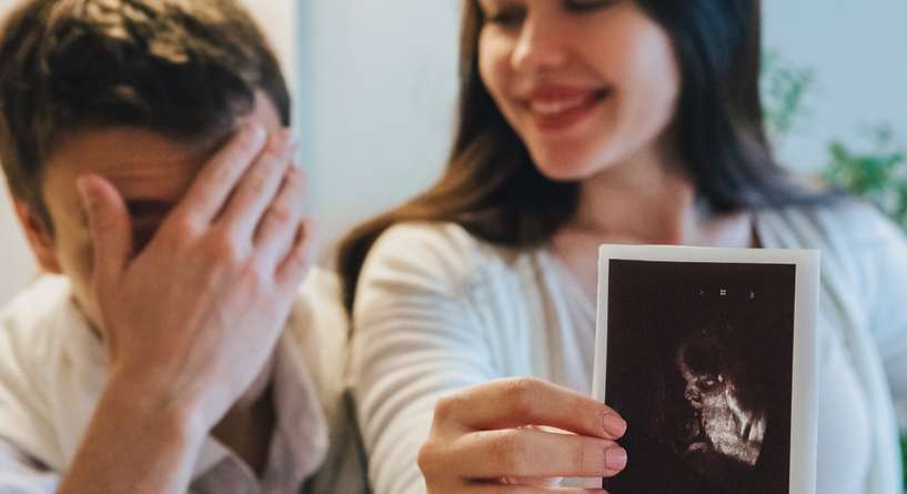زوجان يبرزان صورة الموجات ما فوق الصوتية للجنين