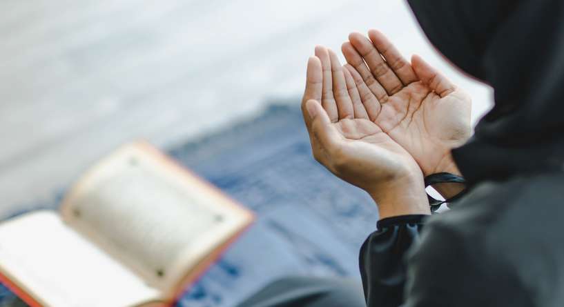 امرأة ترفع يديها بالدعاء