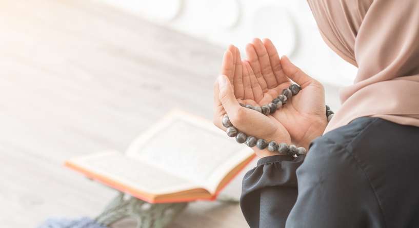 امرأة ترفع يديها بالدعاء