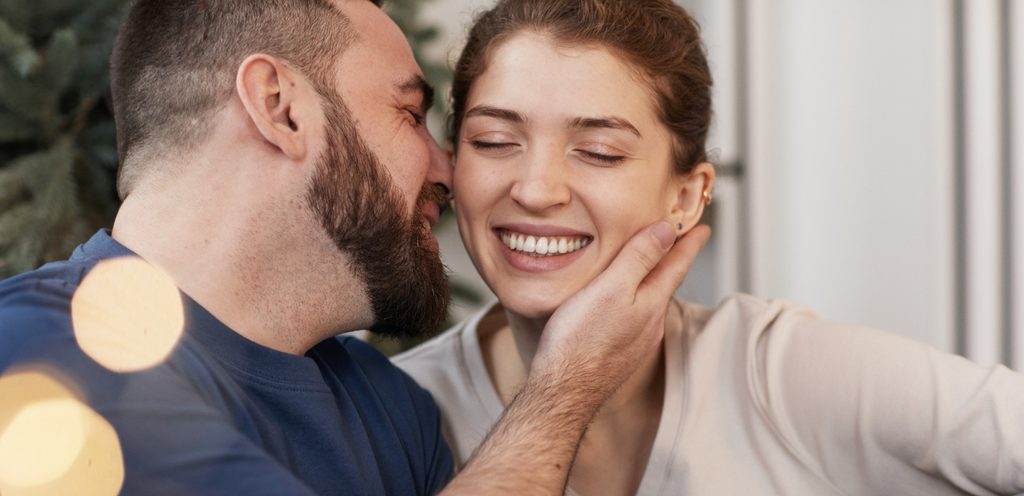 امرأة سعيدة ورجل يقترب منها ليقبّلها في خدّها