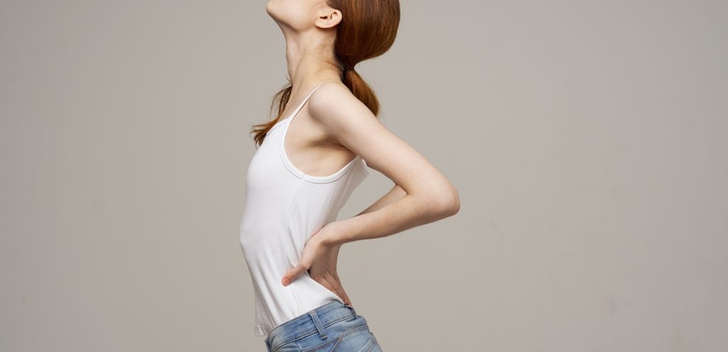شابّة تضع يديها أسفل ظهرها