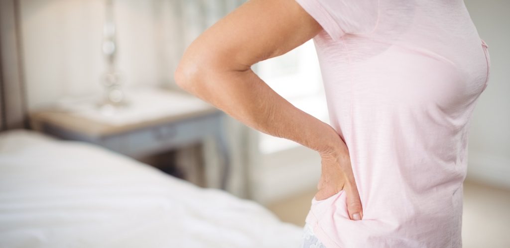 امرأة تضع يدها على ظهرها