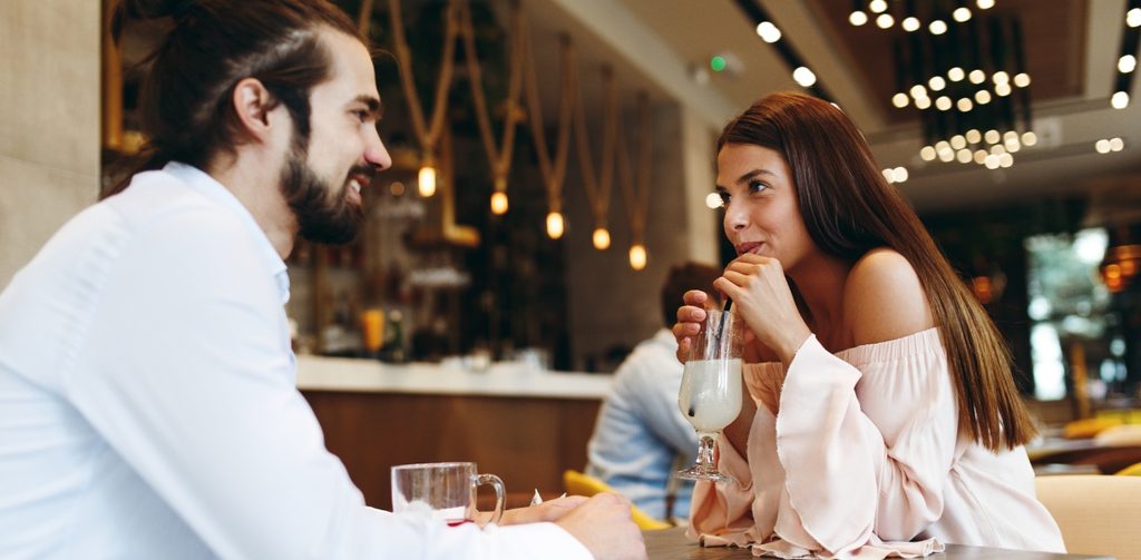 شابّة وشاب في مقهى يجلسان بسعاة