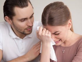 زوج يواسي زوجته بينما هي تبكي