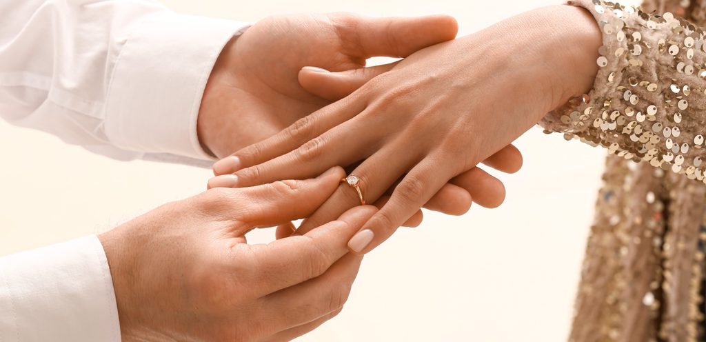 رجل يضع الخاتم في يد زوجته