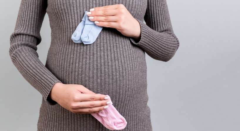 امرأة تحمل بيدها حذاءي توأم