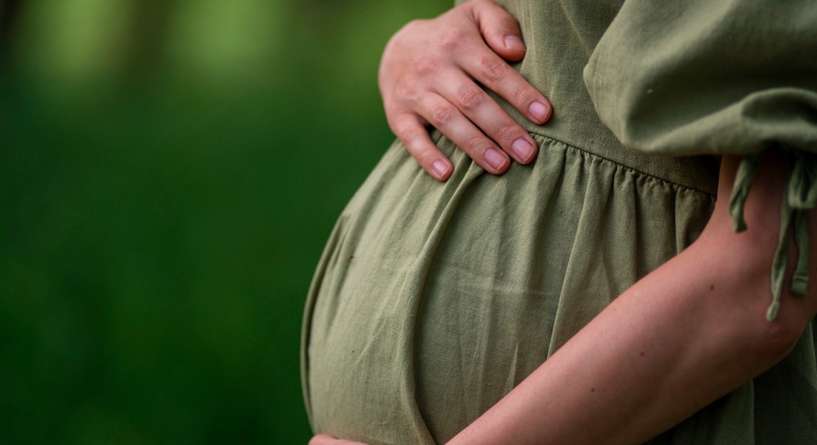امرأة حامل تضع يدها على بطنها