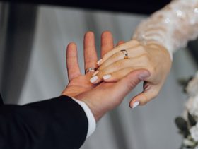 زوج يمسك بيد عروسه