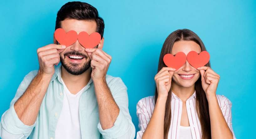 زوجان يضعان قلوبًا حمراء على عينيهما