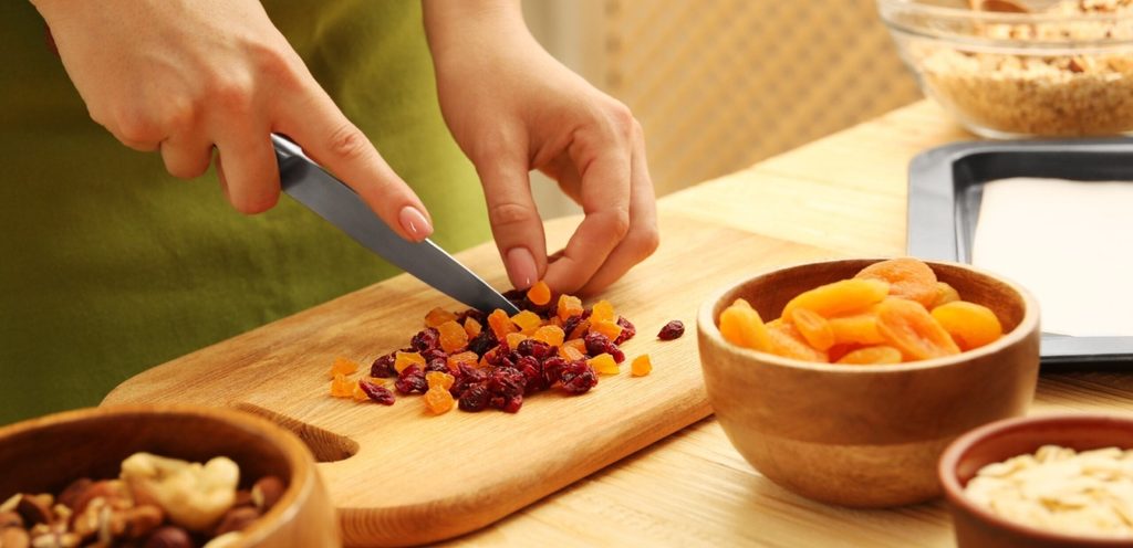 امرأة تقوم بتقطيع المشمش المجفف