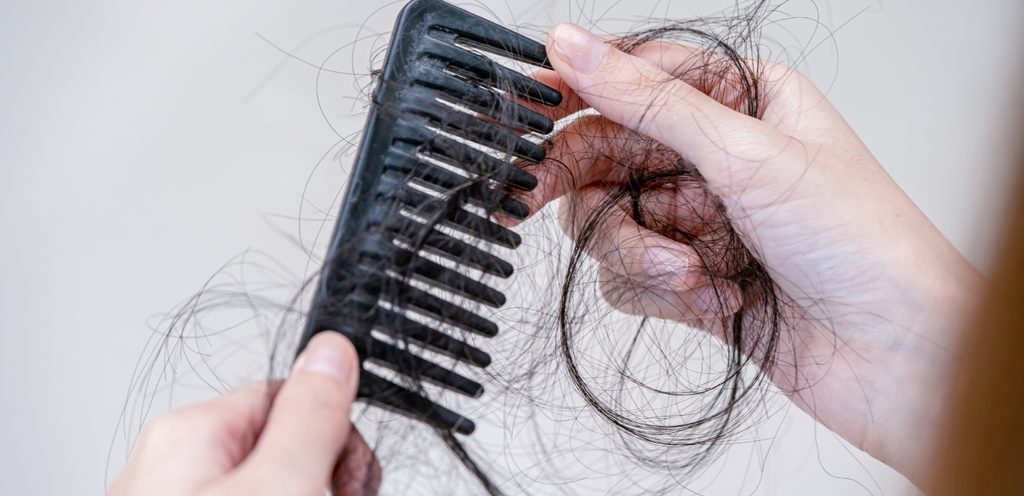 امرأة تنتزع الشعر من فرشاة التصفيف