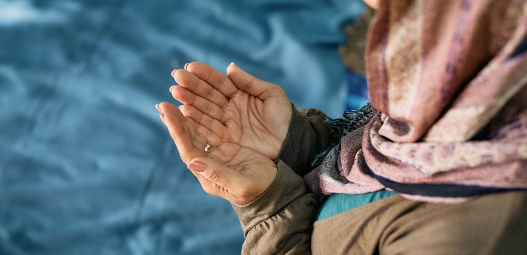 امرأة ترفع يديها لكي تدعي