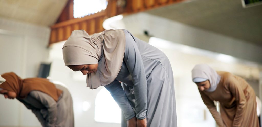 امرأة مسلمة تُصلّي مع نساء أخريات