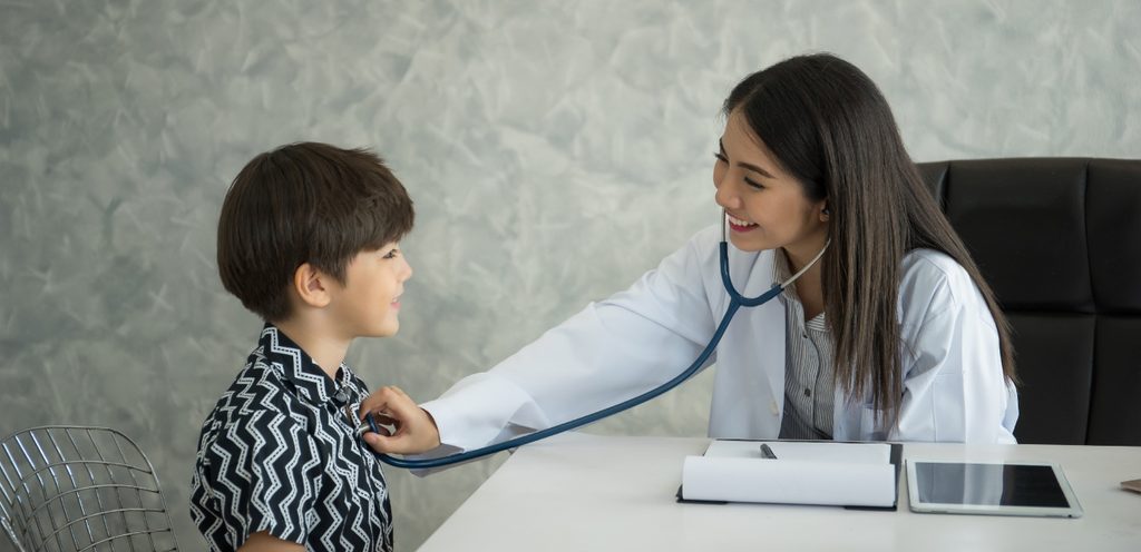 طبيبة تفحص قلب طفل صغير بسماعتها الطبيّة