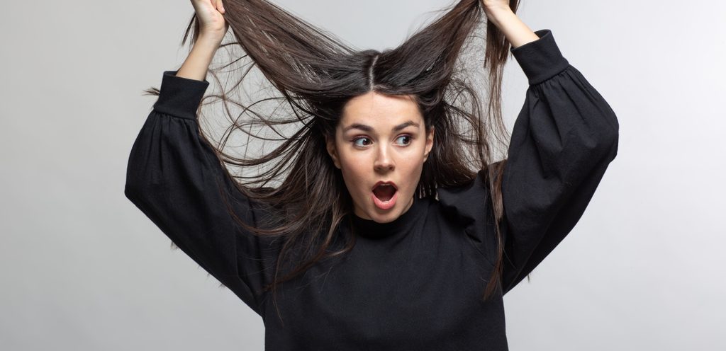 امرأة متفاجئة تمسك شعرها وترفعه لأعلى