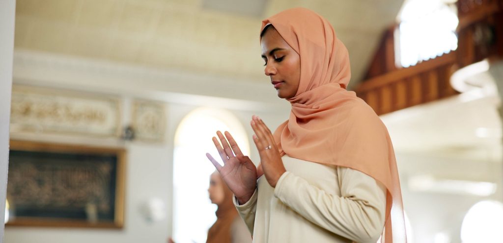 امرأة مسلمة ترفع يديها وتصلي