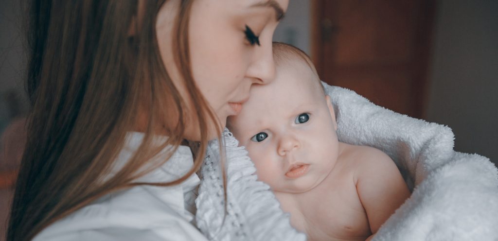 امرأة تحمل طفلها الرضيع