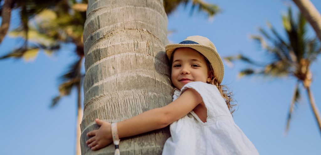 طفلة تعانق جذع شجرة