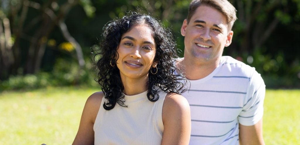 زوجان سعيدان يجلسان جنبًا إلى جنب في الحديقة