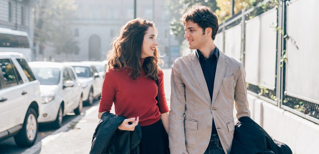 امرأة ورجل يتمشّيان وينظران إلى بعضهما البعض بحبّ