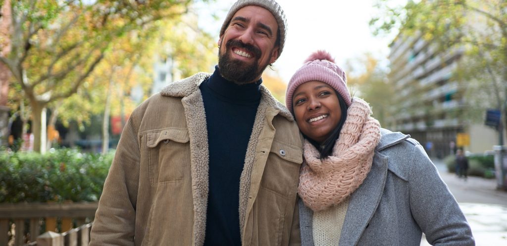 زوجان يتمشّيان سويًا ومبتسمان