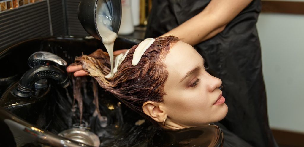 امرأة تصبغ شعرها في صالون تجميل