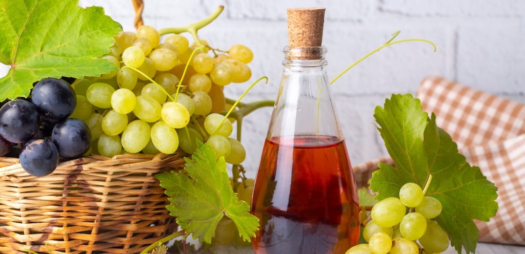 عنب أبيض وأسود مع زجاجة خلّ