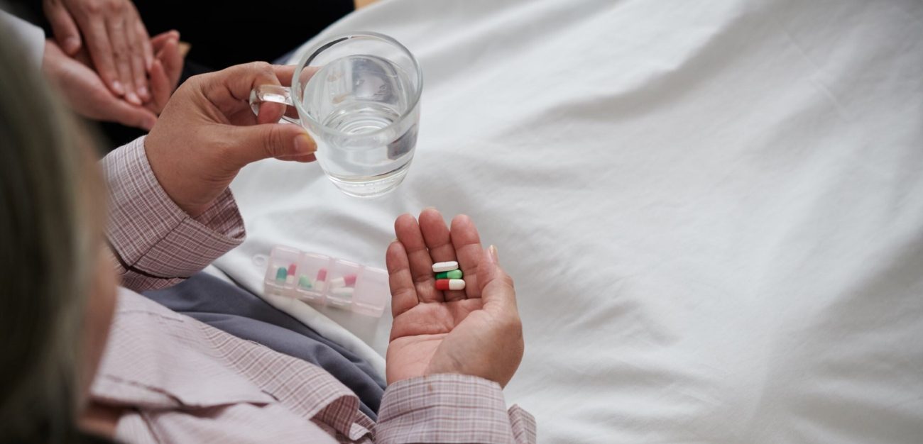 امرأة تحمل بيدها حبات الدواء