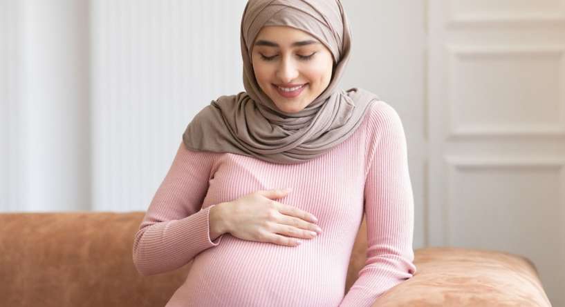 امرأة حامل تنظر إلى بطنها