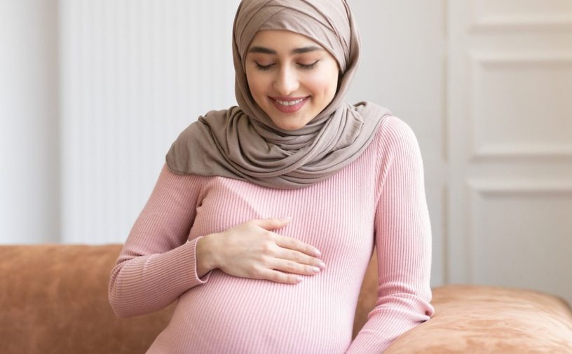 امرأة حامل تنظر إلى بطنها