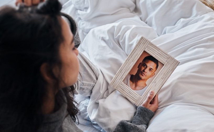 امرأة حزينة تحمل صورة زوجها وتنظر إليها