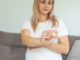 امرأة حامل تحمل مكمل اوميغا 3