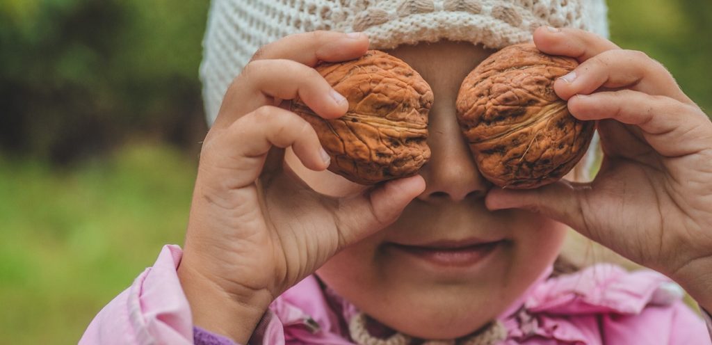 طفلة تضع فوق عينيها حبتي جوز