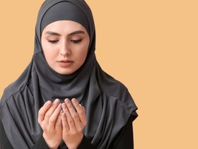 امرأة ترفع يديها بالدعاء