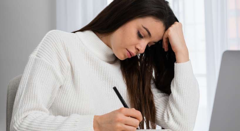 امرأة تكتب رسالة بحزن