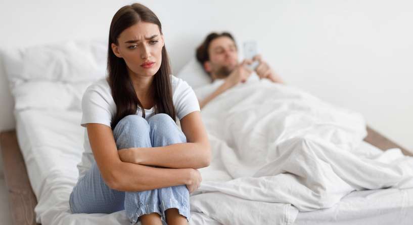 امرأة تجلس حزينة فب الفراش