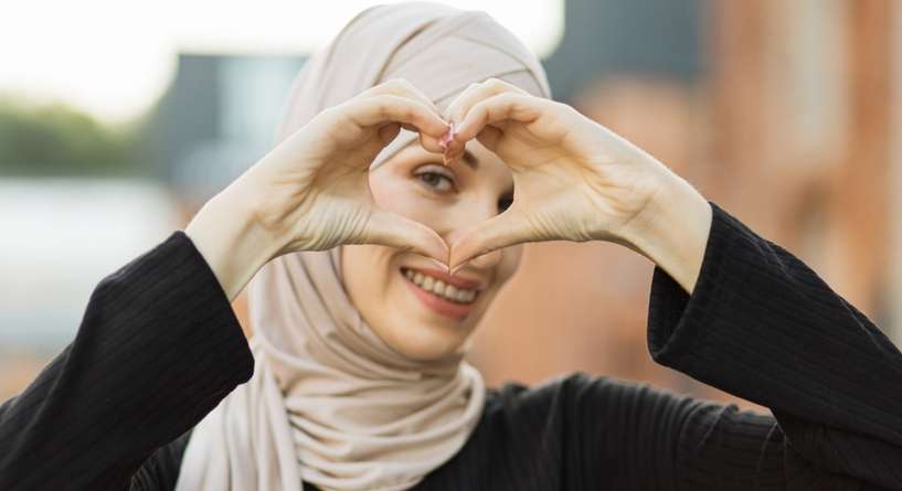 امرأة ترمز بيديها إلى الحب