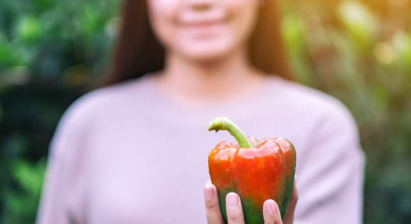 امرأة تحمل بيدها فلفل حلو