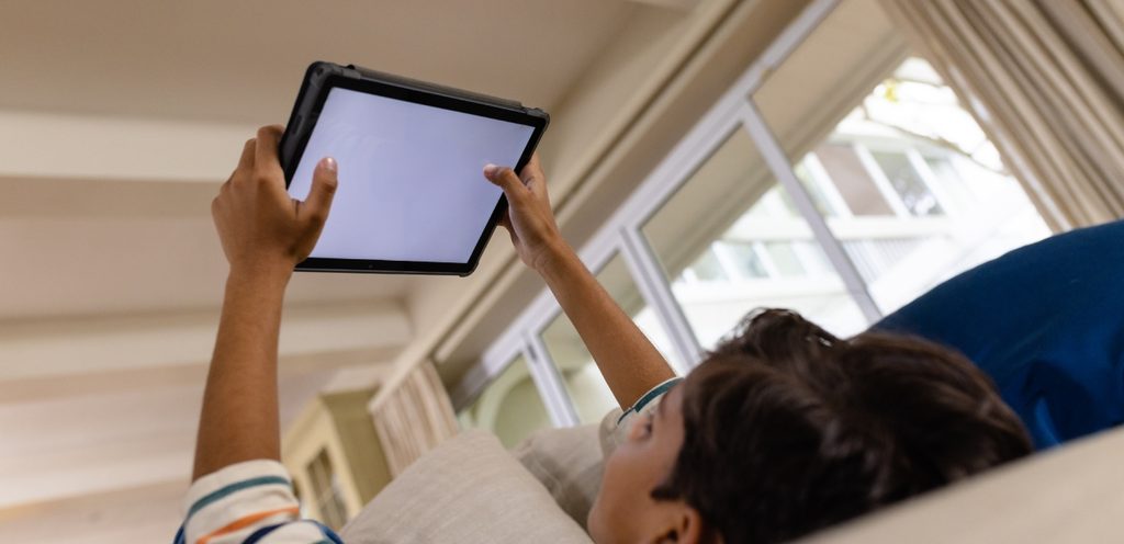 طفل يستخدم جهاز لوحي إلكتروني