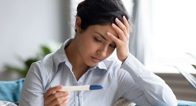 امرأة تحمل بيدها اختبار حمل منزلي